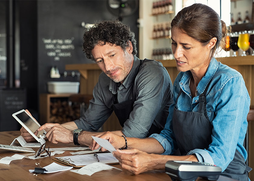 Business owners preparing taxes at a table. Tax-saving strategies for business owners.